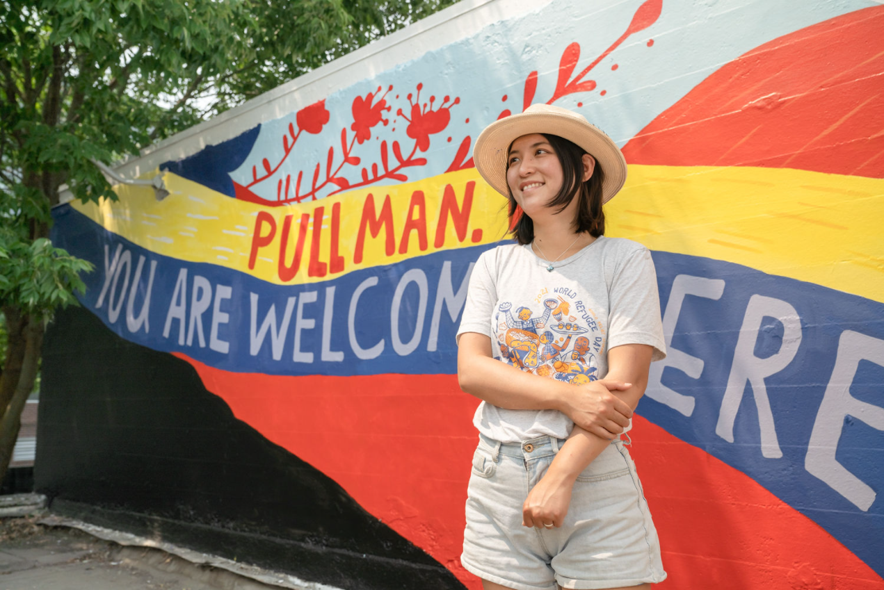 Artist Jiemei Lin stands in front of her Black Lives Matter mural in Pullman, WA