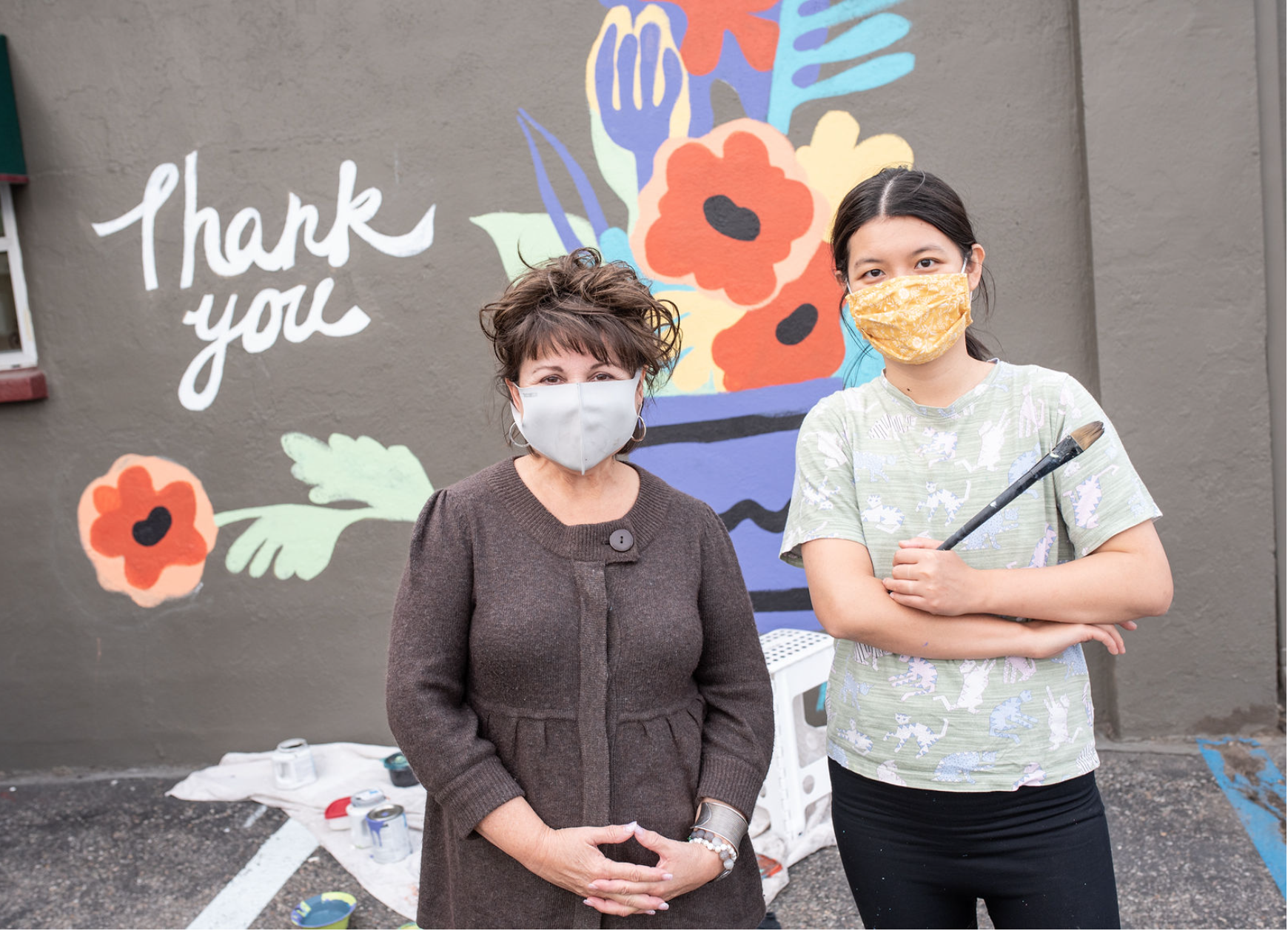Artist JieMei Lin and Sarah standing in front of a mural on North Monroe